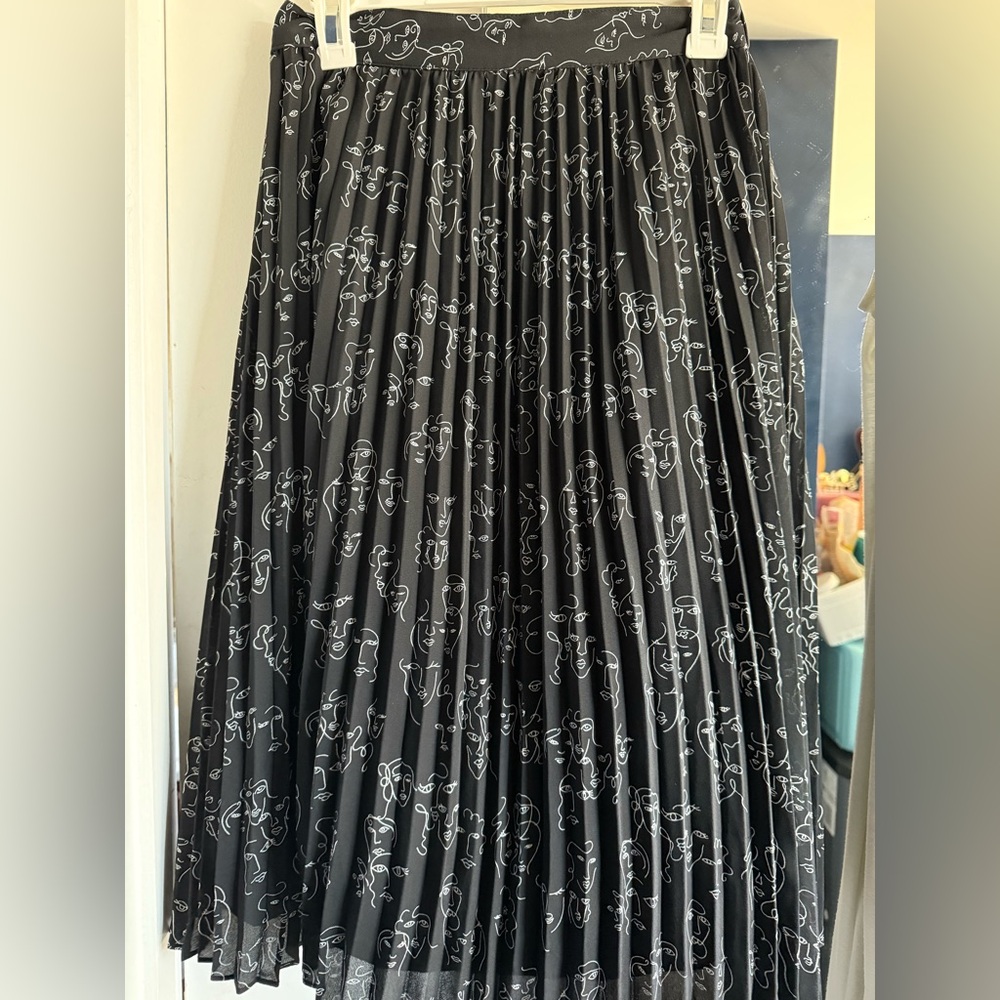 Black pleated skirt with all over faces print